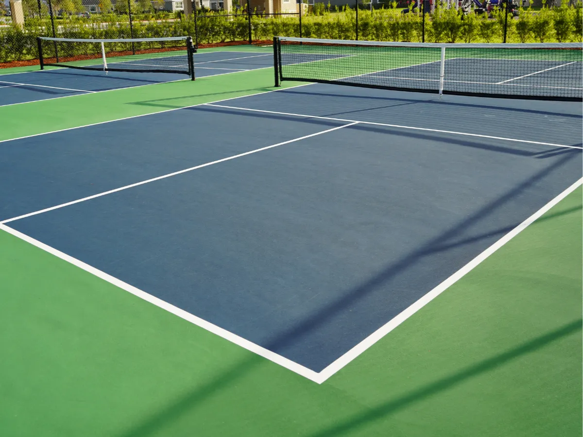 A tennis court with net and grass.